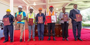 President William Ruto (centre) holds the Affordable Housing Act, alongside Lands CS Alice Wahome (second from right) and Attorney General Justin Muturi at State House on March 19, 2024.