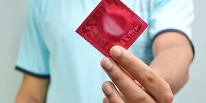 A man displaying a condom.