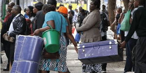 A parent and a student carrying a box during school reopening in January 2023.