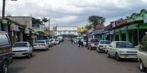 Several cars parked outside businesses in Kericho town