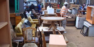 Several items at an auction while buyers walk around in Kenya