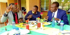 South Mugirango MP Sylvanus Osoro (left) and Kisii Governor Simba Arati (right) enjoy a meal.