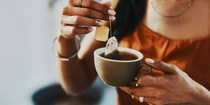 A photo of someone taking a cup of tea.