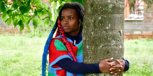 A photo of Truphena Muthoni hugging a tree