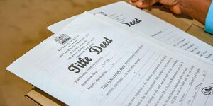 An image showing someone displaying title deeds