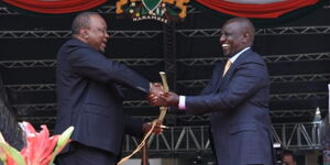 Former President Uhuru Kenyatta handing over a sword to President William Ruto on September 13, 2022.
