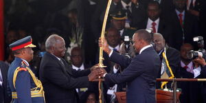President Uhuru Kenyatta (Right) receives the sword of power from former President Mwai Kibaki at the Kasarani Stadium on April 9, 2013.