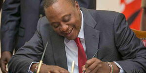 President Uhuru Kenyatta siging a Bill into law at State House in Nairobi, October 13, 2017.