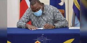 President Uhuru Kenyatta signs a bill into law in December 2020.