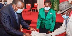 President Uhuru Kenyatta presenting land title deeds to a section of beneficiaries of the National Land Titling Program at KICC, Nairobi in2020.