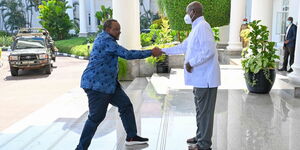 Former President Uhuru Kenyatta greeting President Yoweri Museveni of Uganda at the steps of Uganda's State House on August 5, 2023.  