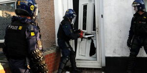 A photo of Greater Manchester Police officers carrying out a raid at a home in 2019.