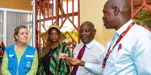 Equity Kakuma Business Growth and Development Manager Daniel Makhulo (Right) discusses refugees' banking experiences to UNHCR Deputy High Commissioner Kelly Clements (left), who was accompanied to the branch by Equity Group Foundation Executive Chairman Dr. James Mwangi (2nd Right) and Safaricom Chief Financial Services Officer Esther Masese (2ndLeft). 