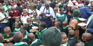 President William Ruto with students at Roysambu Primary School during a lunch break on June 20, 2023.