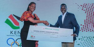 Esther Waititu, Chief Financial Services Officer at Safaricom (left), hands over a cheque of Ksh30 million to Paul Tergat, President of the National Olympic Committee of Kenya (right), during the official Safaricom and Visa sponsorship partnership announcement to support Team Kenya at the 2024 Paris Olympic Games. The event was held at Hyatt Regency, Westland in Nairobi.
