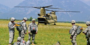 A photo of US army paratroopers conducting equipment checks before a military exercise.