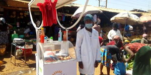 A vendor standing beside his trolley with his goods.