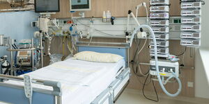 A ventilator next to a hospital bed.