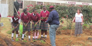 Muli Kituku the founder of Caring Hearts and Hands of Hope teaches high school students how to plant onions.
