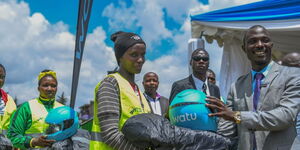 Watu Credit Kenya officials pose for a photo with motorbike riders during a financial literacy clinic in Nakuru County on March 28, 2024.