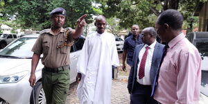 Pastor Ezekiel Odero (in white) arrives at a police station in Kilifi County on Thursday, April 27, 2023. 