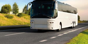 A photo of a white bus on a highway