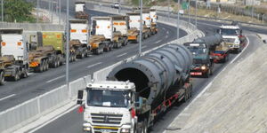 Trucks by Seven Stars Company on a road in Kenya