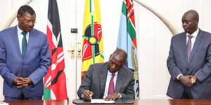 President William Ruto signing bill into law. Onlooking National Assembly Speaker (left) and DP Rigathi Gachagua (right).