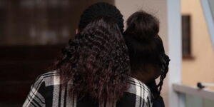 A lady consoles her sad friend. Modelled by Barbra Wambui (left) and Sophie Modaliko (right). 