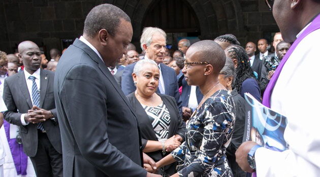 President Uhuru Kenyatta consoles Wambui Kamiru during the memorial service of her husband Bob Collymore at All Saints' Cathedral in Nairobi on July 4, 2019.