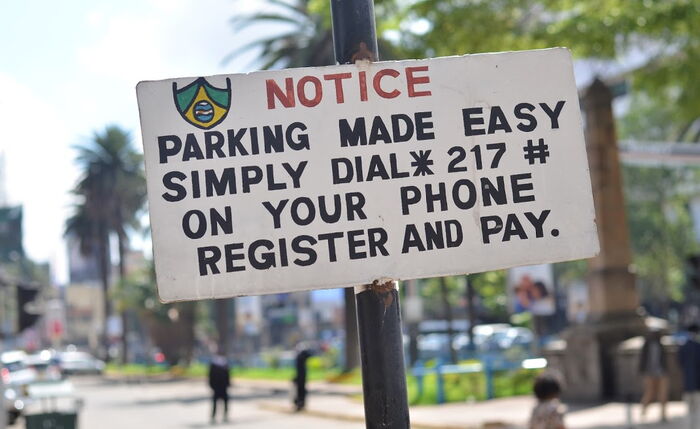 A parking fee payment instruction notice board.