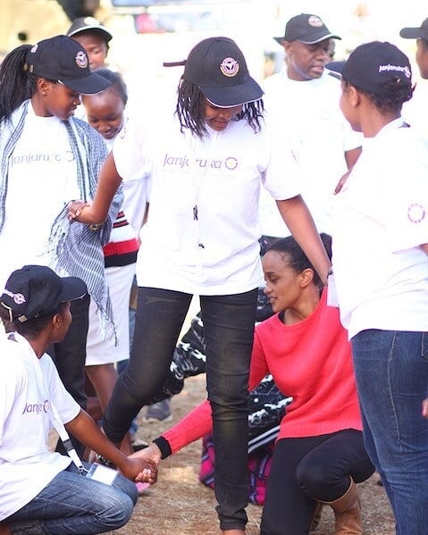 First daughter Ngina Kenyatta (squatting) participates in outdoor games with some beneficiaries of The Kenyatta Trust.