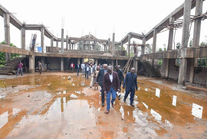 Deputy President William Ruto walks through a flooded structure in Makueni, December 8.