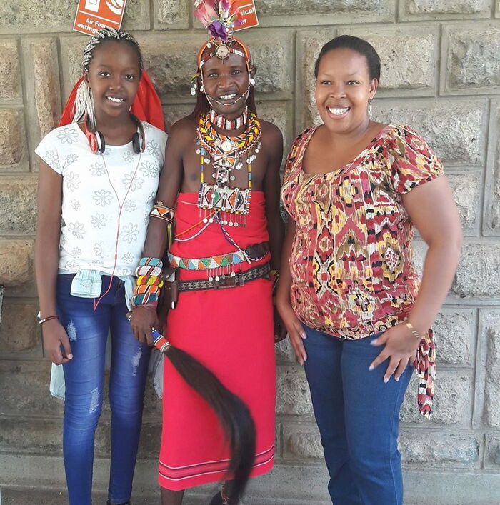 Abby Ruto (l) and her mum Prisca Bett (r) pose with a Masaai.