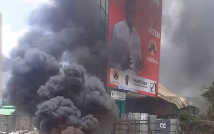 Tyres belonging to Mariga's campaign vehicle being burnt alongside his billboard