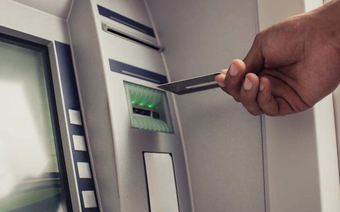 A man ready to insert a card in an ATM machine. Photo: The Standard.