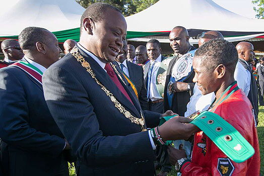 President Uhuru Kenyatta admires Fatuma Zariaka's super bantam weight trophy at State House Nairobi in October 2018.