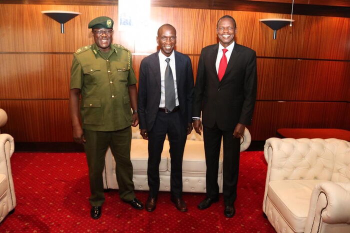 Eliud Kipchoge (centre) poses for a photo with his coach Paul Sang and a Kenya Forest Services (KFS) official after landing in Mombasa on October 19, 2019.