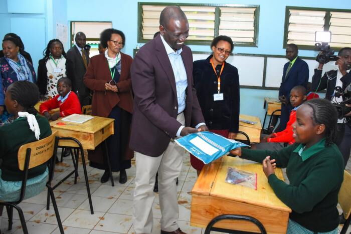 Deputy President William Ruto gives a KCPE candidate exam candidates to sign at Ngong Forest Primary School on Wednesday, October 30.