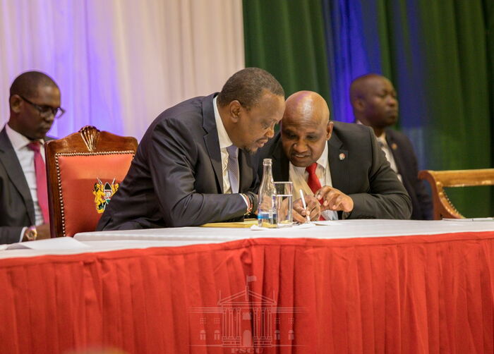 President Uhuru (left) speaking to KRA Director-General James Mburu during the