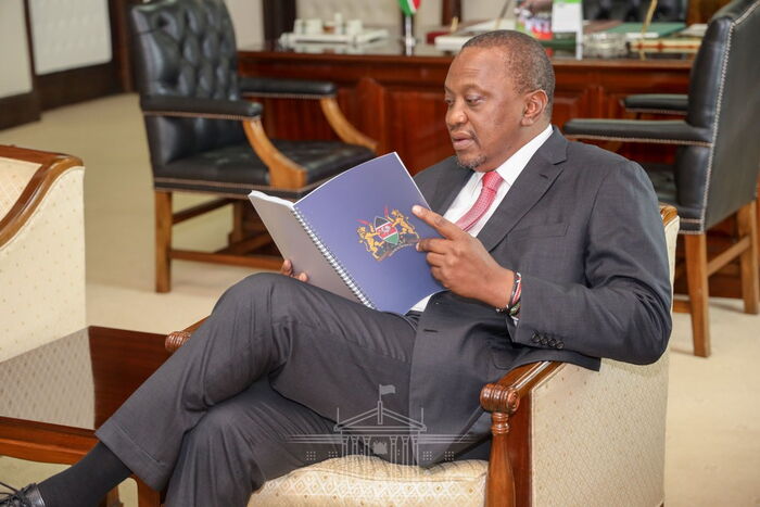 President Uhuru Kenyatta reading the BBI report after receiving it from the task force at State House on Tuesday, November 26, 2019