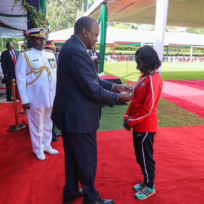 President Uhuru Kenyatta awards marathoner Mary Keitany with the OGW title at Statehouse on December 12