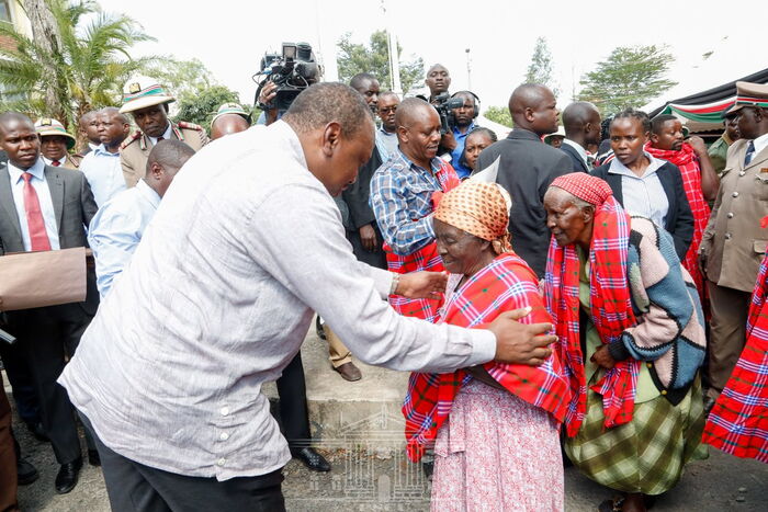 President Uhuru Kenyatta enjoys a light moment with a Nyakinyua dancer in Nakuru County on Tuesday, January 14