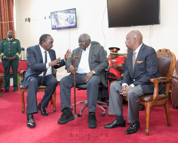 Former President Mwai Kibaki chats with Raymond and Gideon Moi after viewing his predecessor Daniel Arap Moi's body at Parliament buildings on Sunday, February 9