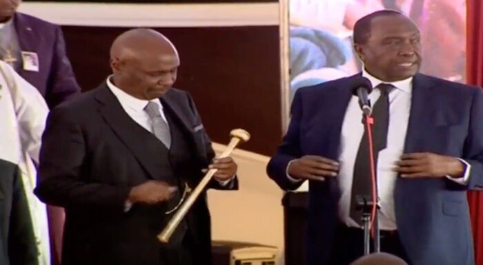 Gideon Moi (l) examines his late father's rungu which was handed to him by his brother Raymond Moi (r).