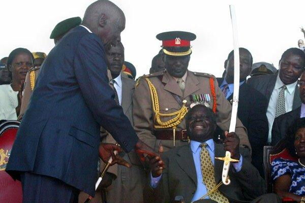 Outgoing president Daniel Moi hands over the instruments of power to incoming Mwai Kibaki at Uhuru Park on December 30, 2002.
