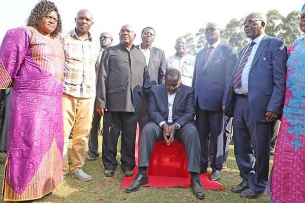 Members of the Abagusii Council of Elders pray for Interior CS Fred Matiang'i during a funds drive at Riokindo Boys High School , Kisii County, on July 26. They urged the CS to vie for presidency come 2022.