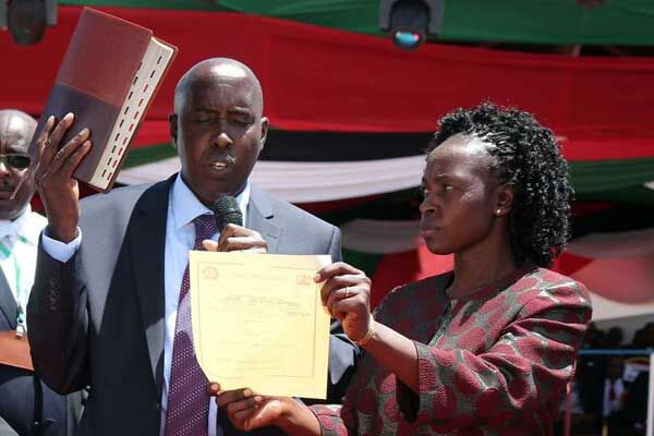 Kajiado County Governor Joseph ole Lenku taking oath of office at Masaai Technical Training Institute on August 18, 2017. Next to him is his wife, Edna
