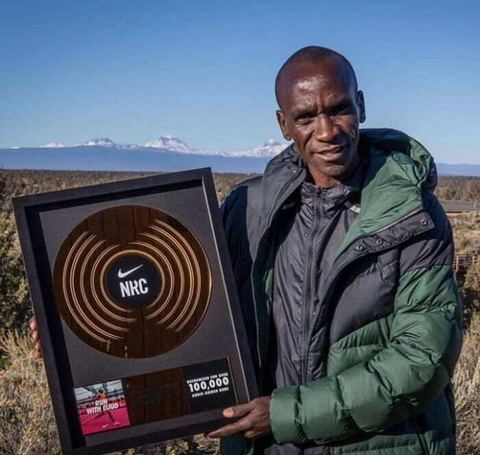 Eliud Kipchoge poses with his gold record award from Nike.