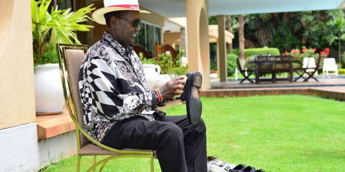 Kenyan Billionaire Chris Kirubi brushes his shoes in front of his home. He revealed that the opportunities he pursued were in line with his vision.